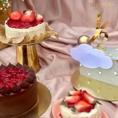 A beautiful spread of my fresh fruit cakes. This photo features mini strawberry cakes and a larger chocolate and strawberry creation, alongside a whimsical half-birthday cake, all ready for a celebration.