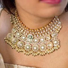 A detailed close-up of a magnificent kundan and polki choker. Notice the intricate setting of each stone and the delicate pearl accents, a testament to the artistry of traditional Indian jewellery.