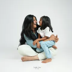 Seated on the floor, a mother and her young daughter look at each other, their faces alive with shared laughter. These are the candid, in-between moments I love to capture.