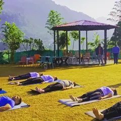 Students in Savasana (Corpse Pose) during our yoga retreat in Rishikesh. Relaxing with the sounds of nature and a view of the mountains is pure bliss.