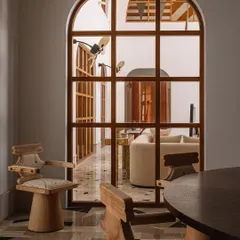 A detail of the 'Kingpin' chairs, which are perfect for long conversations at the dining table. The view looks through an arched window into another living space.