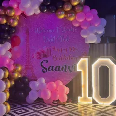 Celebrating a big milestone with a "Double Digit Club" theme for Saanvi's 10th birthday. The setup includes a custom printed backdrop, a large light-up marquee number '10', and a balloon arch in pink, black, and gold.