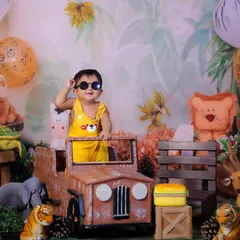Let your toddler's personality shine in a fun themed shoot like this Jungle Explorer setup. With a cool pair of sunglasses and a mini jeep, this little adventurer is ready for anything, surrounded by friendly stuffed animals and safari-themed props.