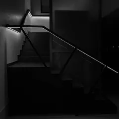 Another perspective of the illuminated staircase, highlighting its sharp, geometric lines against the darkness. This detail showcases our minimalist approach to creating impactful design features.