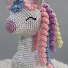 A magical unicorn with a rainbow-colored curly mane and a golden horn. This handmade amigurumi is perfect for anyone who loves a bit of fantasy and sparkle.