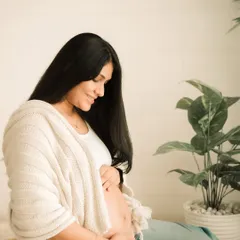 A quiet moment of connection with your baby. This portrait, with soft, natural light, highlights the peaceful bond between a mother and her unborn child.