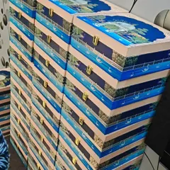Stacks of my custom wedding invitation hampers ready to be sent out. These beautiful trunk boxes feature a serene waterscape design with swans and traditional Indian architecture, promising a grand celebration to come.