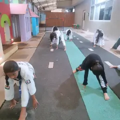 A wide view of our students engaged in stretching exercises. We dedicate a significant portion of each class to flexibility to ensure our students' bodies are prepared for dynamic movements.