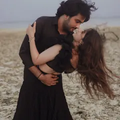 A passionate dip against the dramatic, windswept backdrop of a secluded beach. This image captures raw emotion and movement, telling a story of intense love.