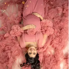 A portrait from above, surrounded by a sea of soft pink tulle. This is a beautiful way to create an artistic and dreamy photo that focuses on your serene glow.