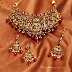 A beautiful temple jewellery set with goddess Lakshmi motifs and red bead drops. This traditional design is available to buy or rent for your special day.