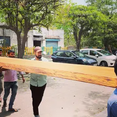 The massive European oak slab being carried into the studio. We source high-quality materials for our custom furniture, ensuring each piece is not only beautiful but also built to last for generations.