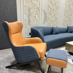 This modern wingback chair in a two-tone design combines tan leather with a quilted navy fabric. Paired with a matching ottoman, it creates the perfect reading nook with a sophisticated, masculine edge.
