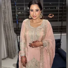The complete look is graceful and timeless. The hairstyle adds a touch of modern elegance to her traditional attire.