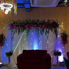 Another angle of the elegant Roka setup, showing the balance of the floral arrangements and the warm glow of the uplighting.