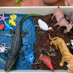 Before the fun begins, I set up inviting sensory trays like this one for sorting land and sea animals. This station uses taste-safe mud and blue-dyed chia seeds, creating a rich tactile world for kids to explore animal habitats.