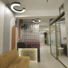 The reception and waiting area at the StyleIn Homes office, featuring a custom 3D wall panel, unique curved lighting fixtures, and a modern color palette. This space is designed to make a strong first impression on visitors.