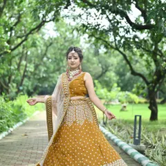 A beautiful mustard yellow lehenga with intricate white embroidery. The full-flare skirt and matching embellished blouse make it a perfect outfit for a Haldi ceremony or spring festival.