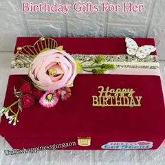 The exterior of the red velvet birthday box, elegantly decorated with a floral arrangement and a golden 'Happy Birthday' sign.