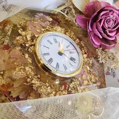 This handmade resin desk clock was created with dried flowers and gold flakes for a client's office. The 8-inch hexagonal clock has a silent mechanism, making it a stylish and peaceful addition to any workspace.