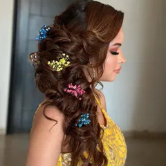 A messy, blooming braid for a Mehendi ceremony. I used colorful baby's breath to match the client's yellow outfit, creating a fun and festive look.