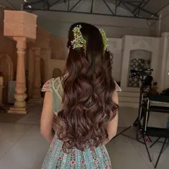 For a soft and romantic look, I styled this client's long hair in flowing, voluminous waves. The half-updo is subtly accented with delicate fresh flower clips, making it an ideal choice for an engagement, Mehendi, or outdoor wedding event.