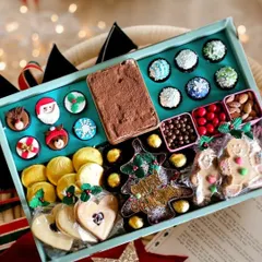 An overhead view of my large Christmas hamper, showcasing the variety of treats inside. You can see the themed cupcakes, gingerbread men, assorted cookies, and chocolates, all artfully arranged.