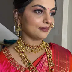 A glamorous look for a Munj ceremony. The makeup features a smoky eye and a bold lip, perfect for the celebratory occasion.