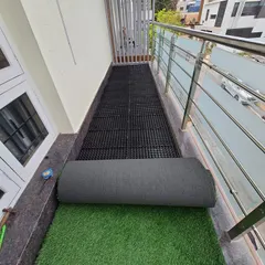 The process of laying artificial grass over the drain cell base. This method ensures a long-lasting and durable green surface.