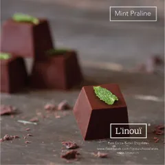 Our Mint Praline, a refreshingly rich confection topped with a fresh mint leaf. This praline perfectly balances the coolness of mint with the depth of dark chocolate.