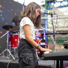 A student pianist completely in her element during the showcase. We ensure every performer gets their moment in the spotlight, backed by a full band and a supportive crowd.
