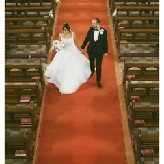 Walking down the aisle as husband and wife. This high-angle shot captures the grandeur of the church and the beginning of a new journey on the iconic red carpet.