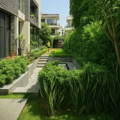 This pathway at a Jaipur residence is flanked by raised garden beds filled with lush hedges and snake plants. The design uses elevation changes and dense greenery to create a sense of journey and discovery as you move through the property.