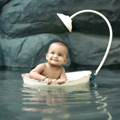 A calm and happy baby enjoying a boat ride in our little pond. This is a unique and beautiful setup for a water-themed shoot.