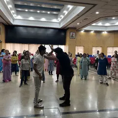 A demonstration of a high block defense during a workshop for a corporate client. The participants observe the technique before practicing it themselves in a controlled, safe environment.