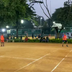 Spectators watch a doubles match from the sidelines. We have benches and seating areas, making it comfortable for friends and family to watch and support.
