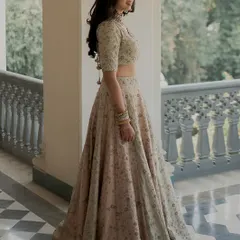 A full-length portrait of a bride in a dreamy, vintage-toned pastel lehenga. The soft, radiant glam enhances her natural beauty and is designed to last through every moment.