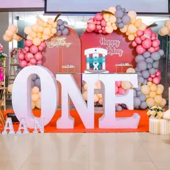 A modern and stylish first birthday decor setup with a teddy bear theme and a warm color palette.