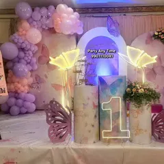 A beautiful butterfly theme for a first birthday. This setup features pastel balloon garlands, light-up butterfly props, and a milestone board showing the baby's first year.