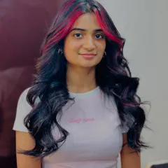 Your dream hair, our expert touch. We added these bold cherry red highlights to frame her face and add a pop of color to her dark hair.