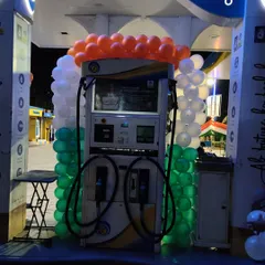 A close-up of a fuel dispenser framed with a tricolor balloon garland. This type of decoration is ideal for retail locations celebrating national holidays.