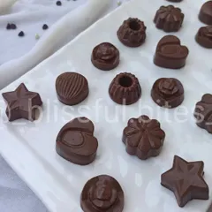 My assortment of homemade chocolates on a white platter. I offer a range of flavours including Hazelnut, Almond, Crispy Crackers, and classic Milk Chocolate.