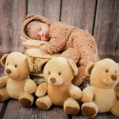 Cuteness overload with this little teddy bear. Dressed in a fuzzy bear outfit and surrounded by friends, this baby is ready for a sweet, cuddly nap.