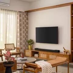 In our 'Palaash' project, the living area is defined by a custom veneered-rattan TV unit that blends rich materials with artisanal warmth. The tall, dual-access frame serves as both a sculptural element and a functional storage spot for everyday essentials.
