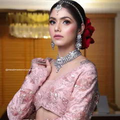 A stunning shot from one of our editorial bridal campaigns. This look features sharp, defined makeup with a bold red flower in the hair, creating a modern yet traditional feel.