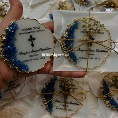 A set of luxury baptism favors, featuring a modern design with blue crystals and gold accents. Each one is also a magnet, making it a practical and beautiful keepsake for guests.