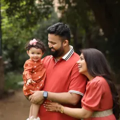 A sweet family cuddle surrounded by nature. The soft, natural light and lush green background create a warm and intimate feel for this outdoor portrait.