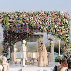 A moment of union under a canopy of thousands of pastel hydrangeas and roses. The sheer density and artistry of the floral design created a truly immersive and romantic atmosphere for the varmala ceremony.