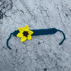 A close-up of my handmade sunflower headband. This features a single, detailed sunflower on a comfortable teal band. It’s a perfect little accessory for a touch of sunshine.