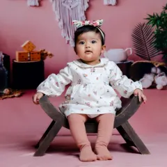 Swaddled with love, sprinkled with magic. A beautiful portrait against a soft pink backdrop.